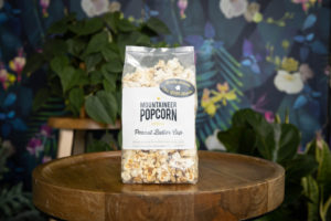 wv product photography, gourmet popcorn in front of a dark floral backdrop