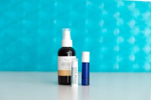 beauty products in front of bright blue texted backdrop