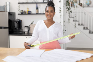 realtor with a measuring tape in a white kitchen
