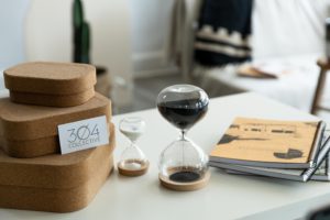 two sand hourglasses on a white desk with neutral details in a natural light photography studio