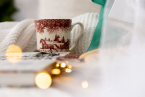 a christmas mug on a white bed